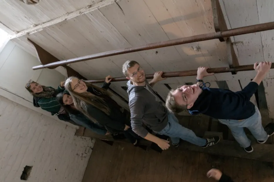 Vier Studierende stehen hinter einer Orgel und schauen nach oben