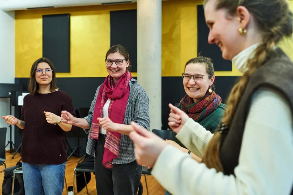 4 Studentinnen schnipsen mit den Fingern beim Chorworkshop